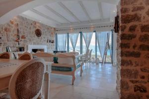 a living room with a table and chairs and windows at Lilian Horizon in Tolo