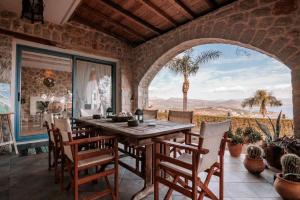 a dining room with a wooden table and chairs at Lilian Horizon in Tolo