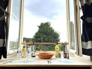 a counter with bottles of wine and a window at Charmant cocon, Lagny sur marne, parking, wifi, proche Disney RER in Lagny
