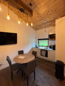 a dining room with a table and a kitchen at The Stags Den in Longton