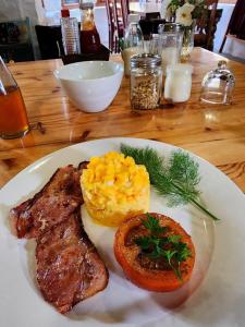 a white plate of food with meat and scrambled eggs at The Bethesda in Nieu-Bethesda
