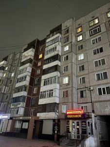 a tall building with a sign in front of it at Elegant Home Stepnoy in Karagandy