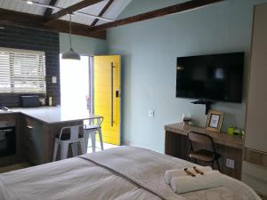 ein Schlafzimmer mit Bett und Schreibtisch sowie eine Küche in der Unterkunft Leipoldt Self-Catering Accommodation in Secunda