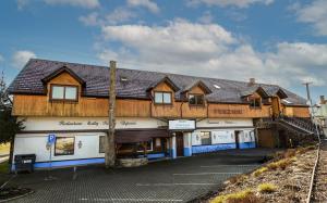 a building with a wooden roof on top of it at Penzion U Holuba in Hradčovice