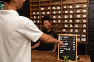 a man is standing at a counter with a sign at Marilyn Boutique Hotel in Durban +43 photos
