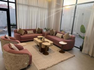 a living room with couches and tables and windows at شاليهات بلانكا الفندقيه in Obhor