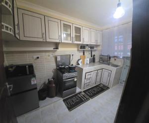 a small kitchen with white cabinets and a stove at Sing' Homes in Eldoret