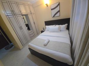 a bedroom with a large bed with white pillows at Sing' Homes in Eldoret
