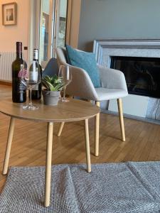 a living room with a table with wine glasses and a chair at Top Lake View in Faggeto Lario 