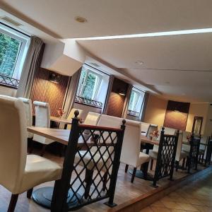 a dining room with a table and chairs and windows at Hotel Loucky in Litvínov