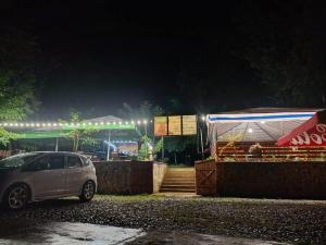 a car parked in front of a building at night at Campsite under two oaks in Itʼkhvisi