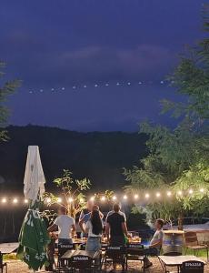 a group of people sitting at a table at night at Campsite under two oaks in Itʼkhvisi