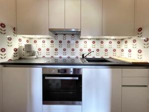a kitchen with white cabinets and a stove top oven at Chalet Cristall Superior Appartement 9 in Leutasch
