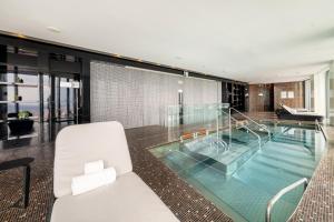 a glass house with a swimming pool and a white chair at Eurostars Madrid Tower in Madrid
