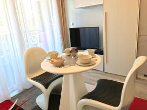 einen kleinen Tisch mit Stühlen und einen TV in einem Zimmer in der Unterkunft Royal Promenade in Nizza