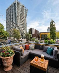a patio with a couch and a table on a building at North-Hotel in Hamburg