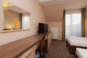 a hotel room with a television and a bed at Hotel Green in Dolný Kubín