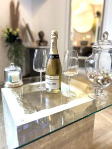 a bottle of champagne and two wine glasses on a counter at Charmant cocon, Lagny sur marne, parking, wifi, proche Disney RER in Lagny +14 photos