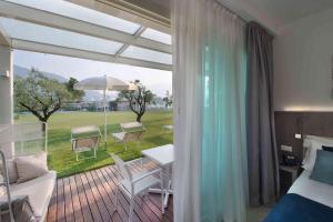 a bedroom with a balcony with a bed and a table at Seven Park Hotel Lake Como - Adults Only in Colico