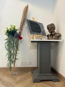 a table with a statue and a vase of flowers at Charmant cocon, Lagny sur marne, parking, wifi, proche Disney RER in Lagny