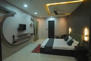 a hotel room with a bed and a tv at Kasa Courtyard Hotel in Begusarai