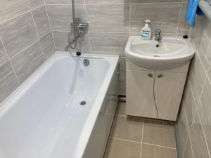 a bathroom with a sink and a bath tub next to a white sink at Apiņa 18 in Valmiera