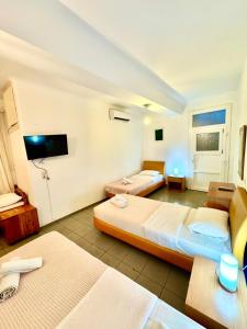 a hotel room with two beds and a flat screen tv at Anna in Megali Ammos