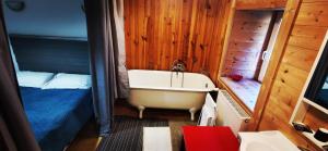 a bathroom with a bath tub and a bed at Atelier du pont de Mars in Mars +2 photos