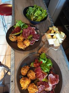 three plates of food on a wooden table at Atelier du pont de Mars in Mars