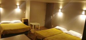 a hotel room with two beds and a table at Atelier du pont de Mars in Mars