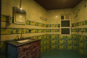 a dirty bathroom with a sink and a window at Kasa Courtyard Hotel in Begusarai