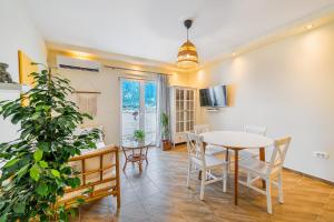 a dining room with a table and a potted plant at Relaxing 2 bedroom apartment with Bay View and Parking in Prčanj