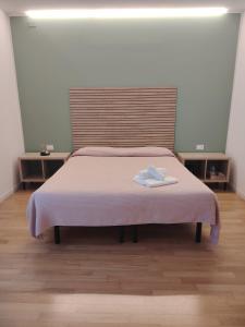 a bed with a pink blanket and two towels on it at Magnolia Room & Breakfast in Faenza +49 photos