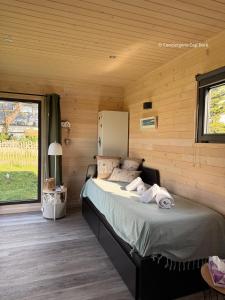 a bedroom with a bed in a log cabin at La Roulotte - Tiny House 150m de la Plage in Portbail