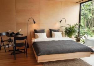 a bedroom with a bed and a table and a window at Domy w ogrodzie - Riverfront cabins in Poznań