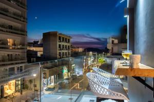 a balcony with a view of a city at night at Melina's - Urban Luxury 2BR 2Bath 2Balcony Apt - Heart of Chania, Private Parking Available 800m in Chania