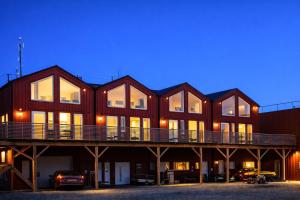 a large red building with a deck at night at Finnvika Panorama Corner in Vestvågøya