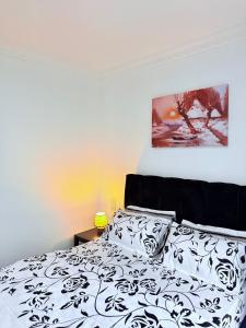 a bedroom with a bed with a black and white comforter at Lumora Homes in Arusha