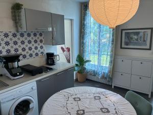 a kitchen with a washing machine and a table at Chez iris in Noisy-le-Grand