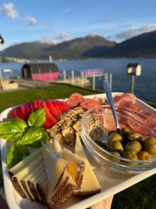 a plate of cheese and crackers on a table near the water at Charming tiny house with panorama view in Sandane +33 photos