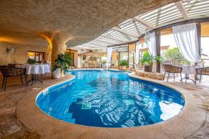 a large swimming pool in a building with a ceiling at Cnaan Village Boutique Hotel & Spa in Had Nes +23 photos