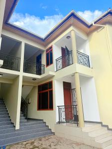 a white house with stairs and balconies at Lumora Homes in Arusha
