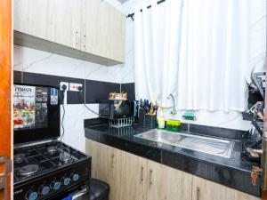 a kitchen with a sink and a stove at Cosy 1 Bedroom in CBD Mombasa with City View in Mombasa