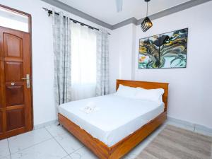a bedroom with a bed and a door at Cosy 1 Bedroom in CBD Mombasa with City View in Mombasa