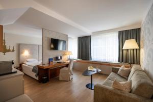 a hotel room with a couch and a bed at Boutique Hotel Das Tigra in Vienna