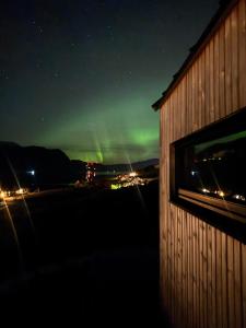 a view of the northern lights from a building at night at Charming tiny house with panorama view in Sandane
