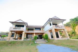 a large white house with a porch and stairs at villa Tip in Ban Na An