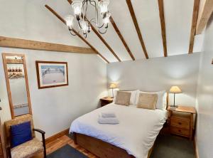 a bedroom with a bed and a chair at All Seasons Cottage Breaks in Saxmundham