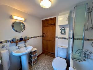 a bathroom with a sink and a toilet and a shower at All Seasons Cottage Breaks in Saxmundham +130 photos