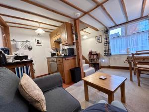 a living room with a couch and a table at All Seasons Cottage Breaks in Saxmundham
